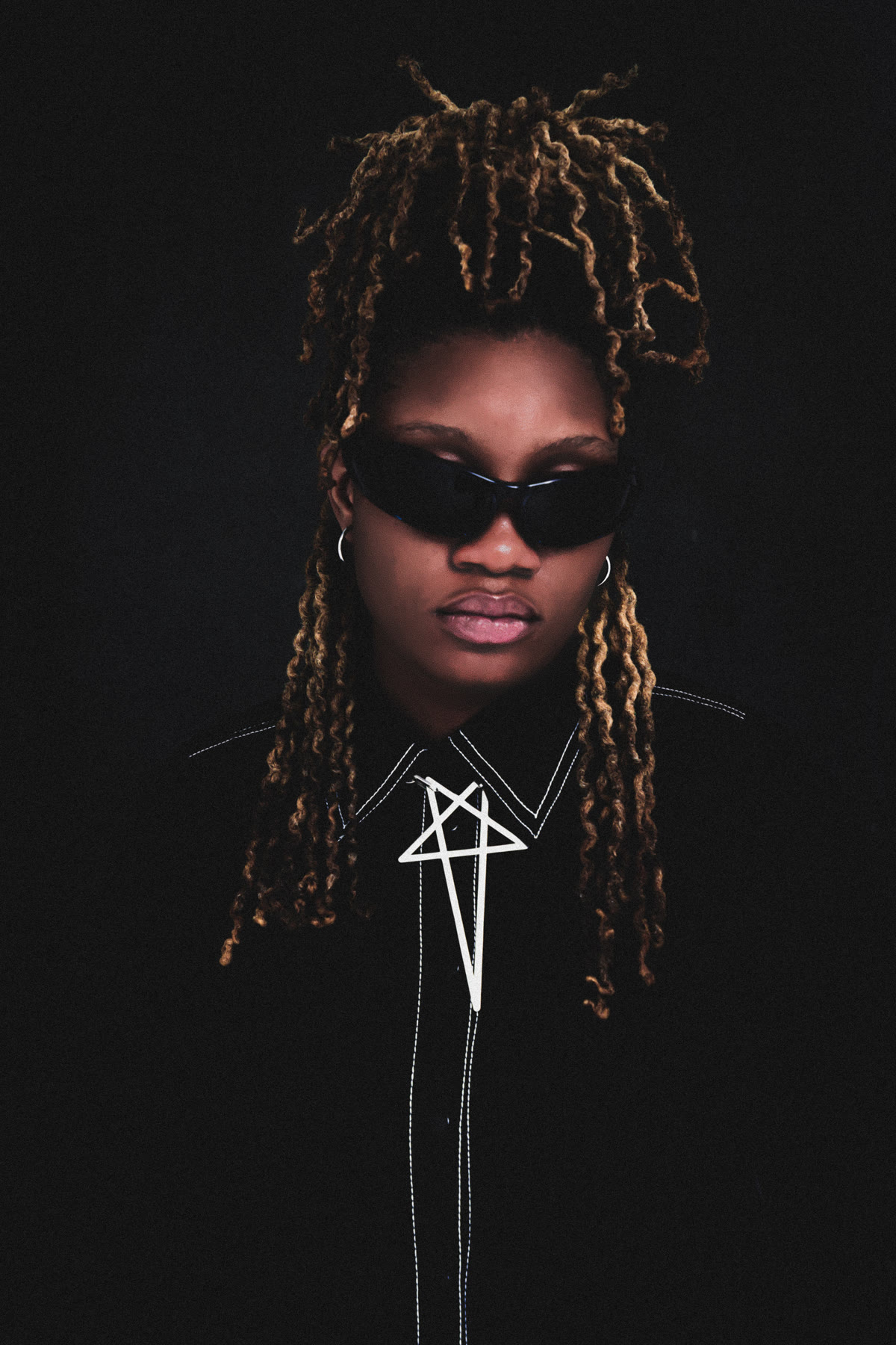 Aniko wearing sunglasses and black in a close studio portrait